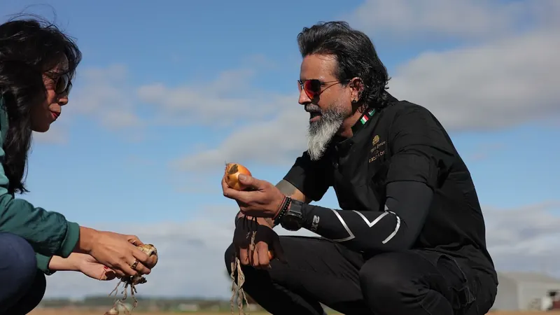 Chef Ash holding an onion in the field