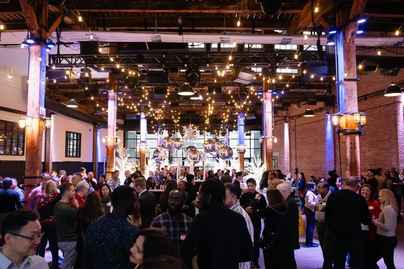 A packed Marigolds & Onions corporate holiday party under string lights